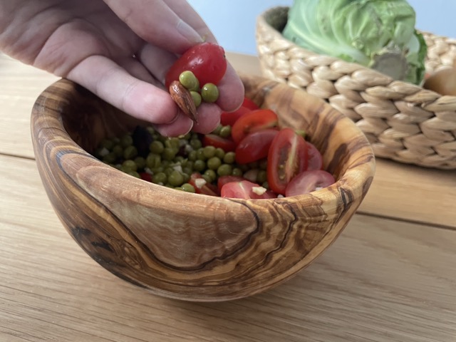 Erbsen und Tomaten mit der Hand essen